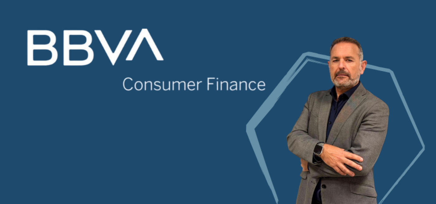 Banner corporativo do BBVA Consumer Finance com fundo azul. À direita, um homem de fato cinzento e camisa escura posa com os braços cruzados, transmitindo confiança e profissionalismo. O logótipo do BBVA Consumer Finance aparece à esquerda.